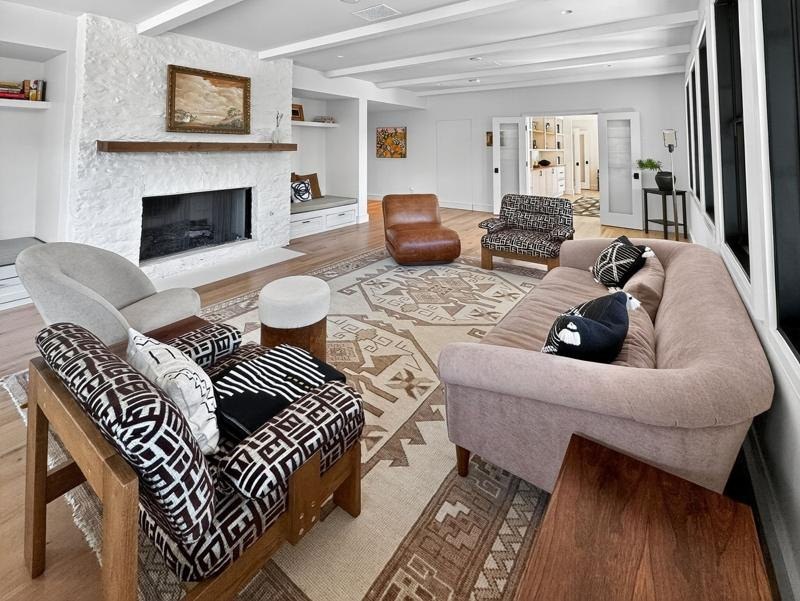 A living room with a white brick fireplace and a leather sofa