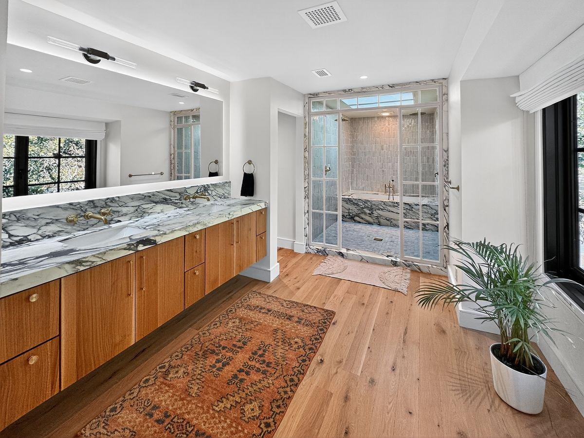 After: a long marble vanity, oak floors and a glass shower