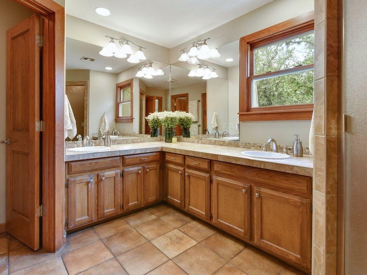 Before: an L-shaped oak vanity with tile floors