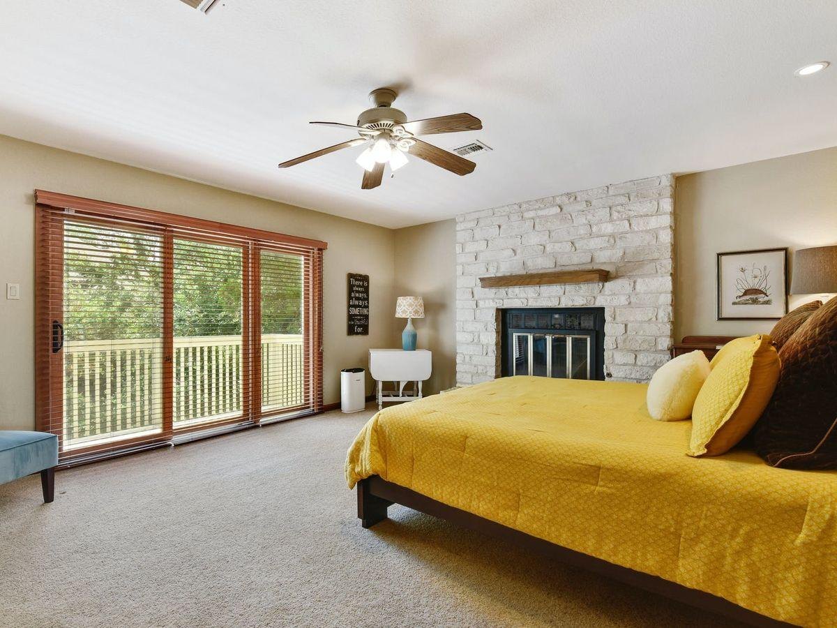 Before: a carpeted bedroom with a stone fireplace and a sliding door