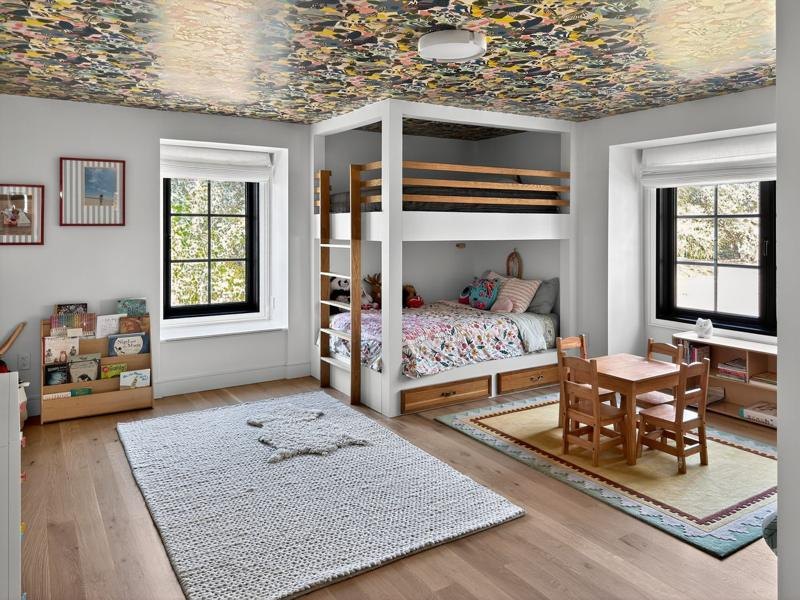 A children’s bunk room under a patterned ceiling