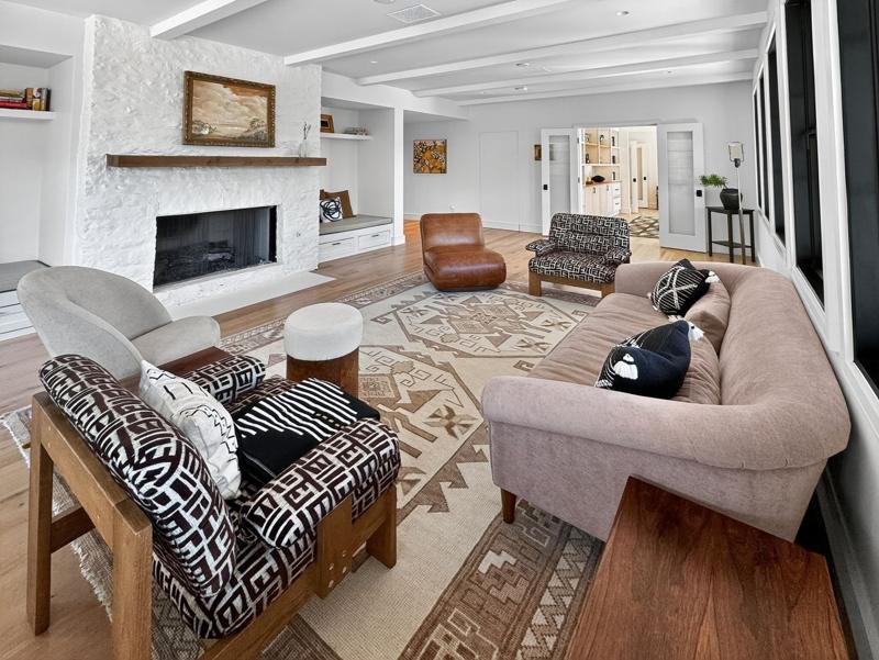 A living room with a white brick fireplace and a leather sofa