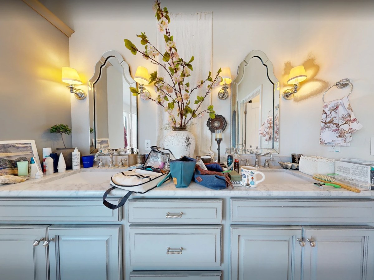 Before: a gray double vanity under two arched mirrors