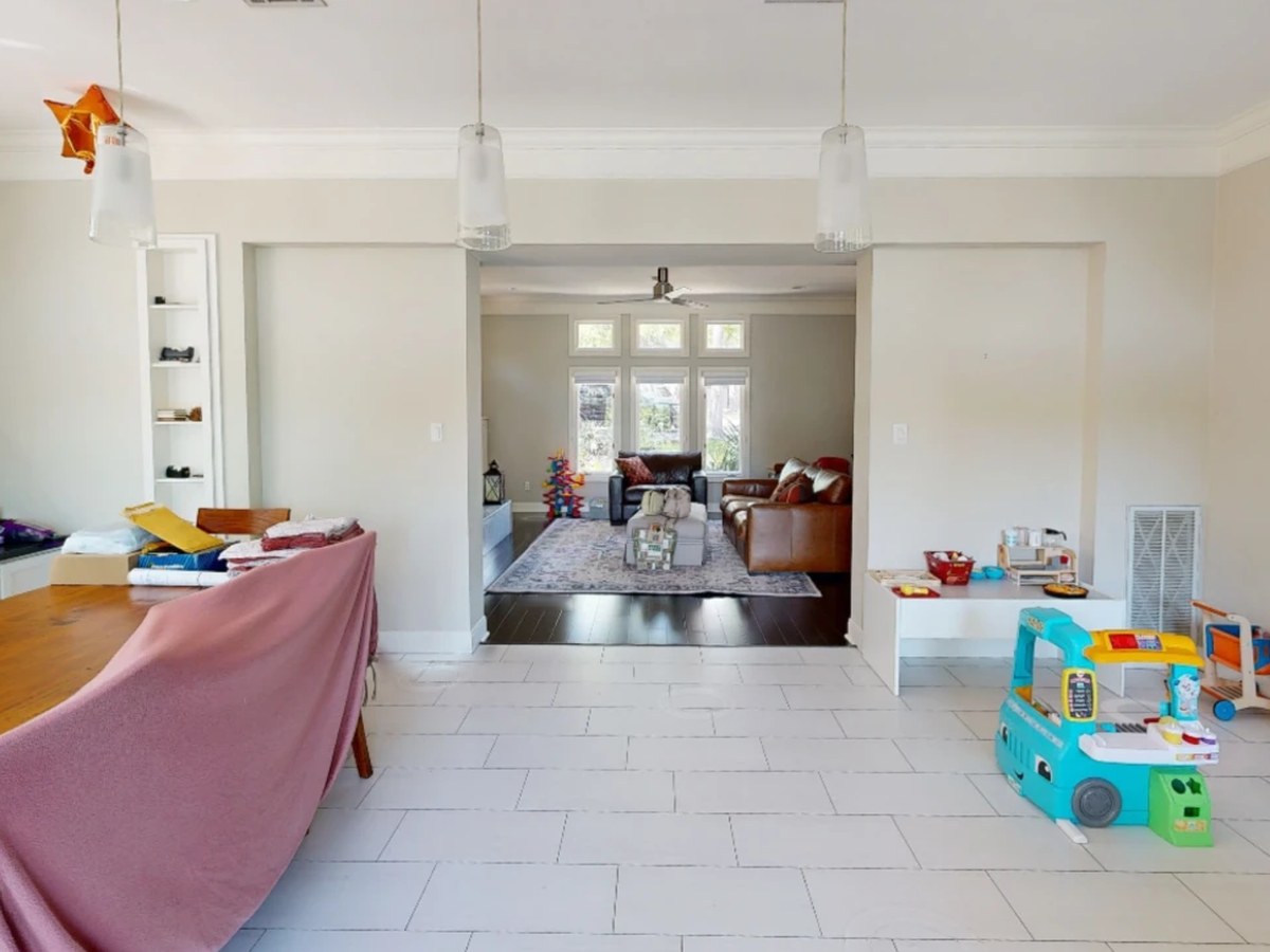 Before: a tiled dining room with a long table and toys, open to the living room