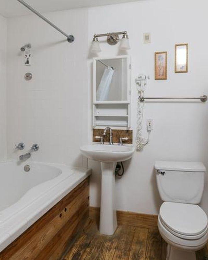 Before: a bath with a tub, a pedestal sink and white tile