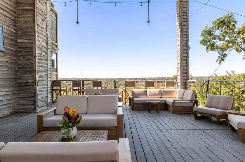 A deck above the river with low sofas