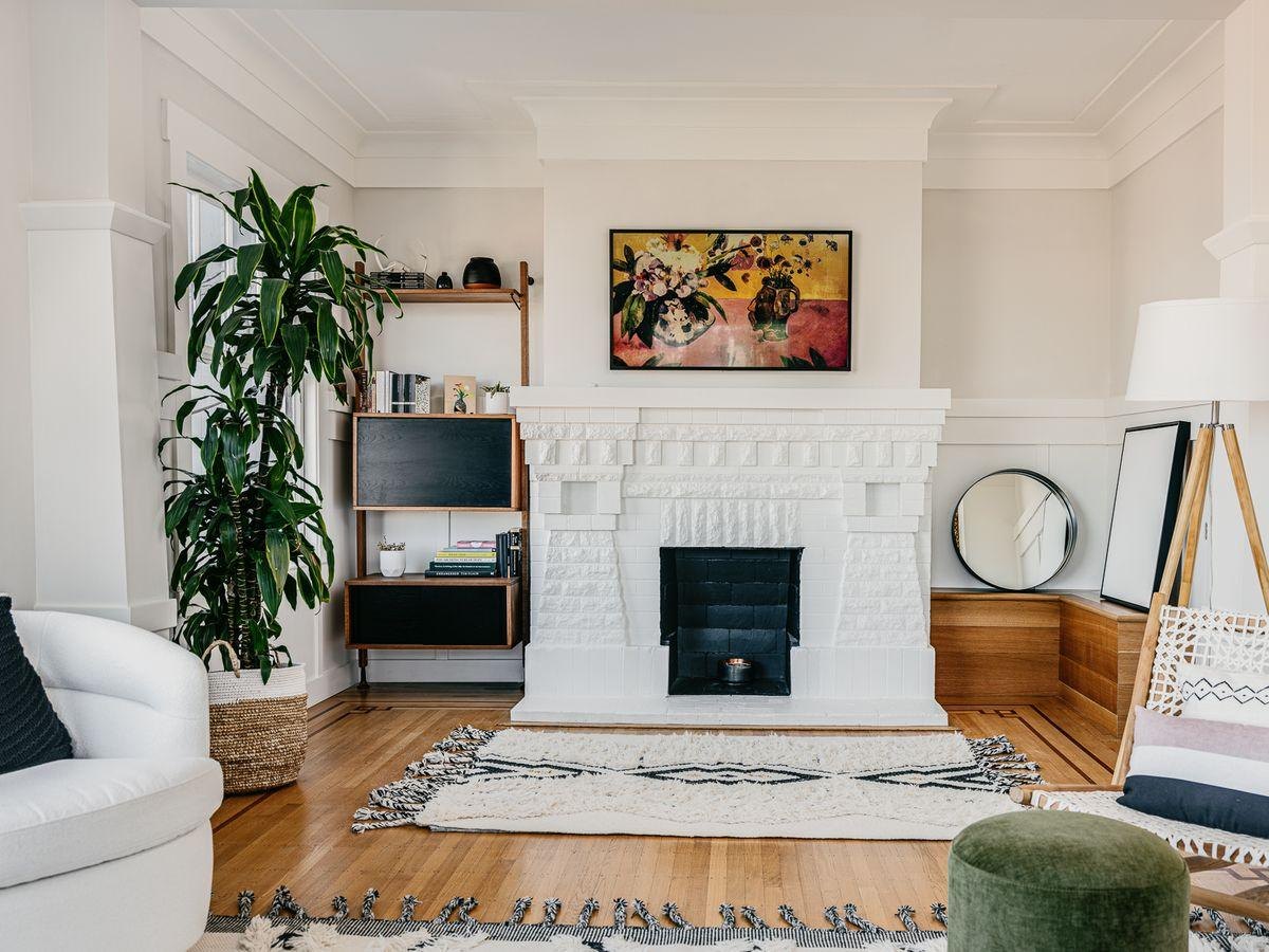 After: the same fireplace painted white, with a pale rug and a plant